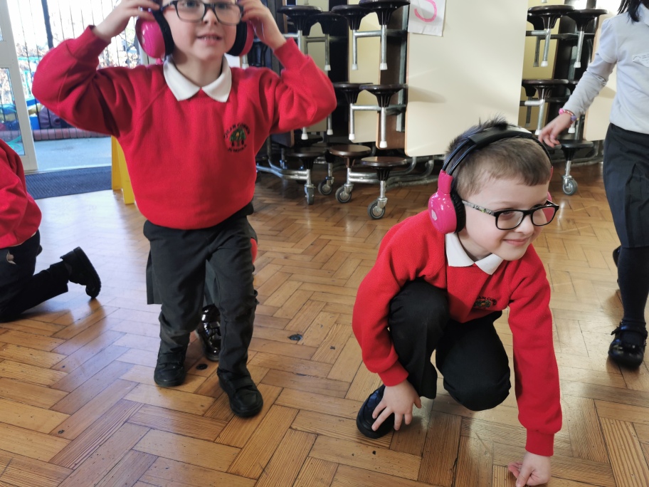 Two Cheam Commons Infants students crouch on the floor as they use Now Press Play.