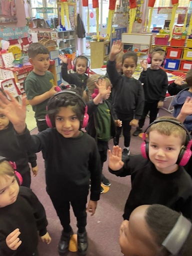 Young Cheam Farm students wave at the camera while using Now Press Play in their classroom.