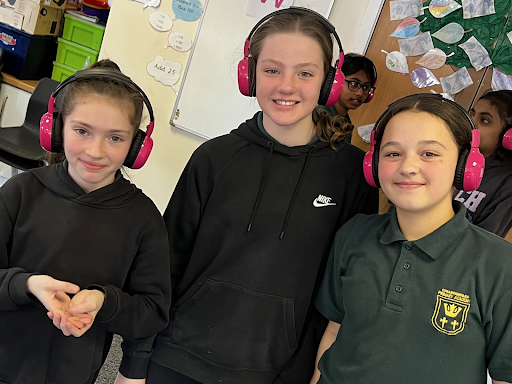 Three Cheam Park Academy students smile while using Now Press Play.