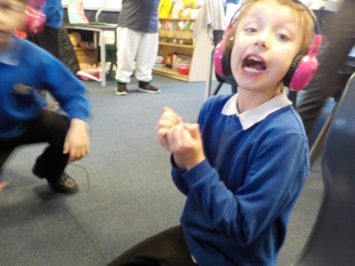 A boy at Chellow Heights Special School smiles while he uses Now Press Play in his classroom.