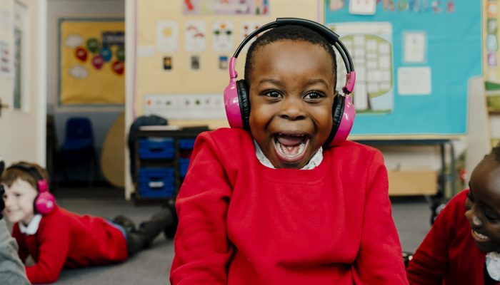 A boy screaming happily using a Now Press Play sensory learning Experience
