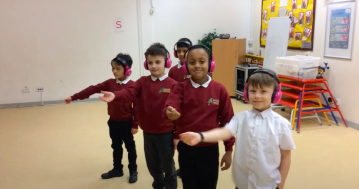 Four boys from Woodland View Primary School enjoy using Now Press Play in their school hall.