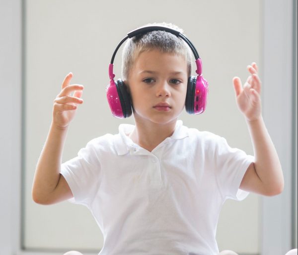 Primary school student using Now Press Play pink headphones