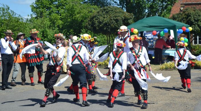 A group of men morris dancing in a street on May Day.