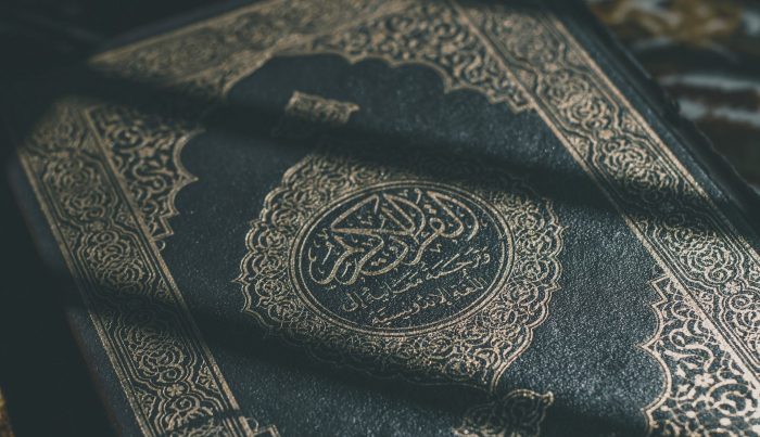 A close-up image of a green and gold Qur'an.