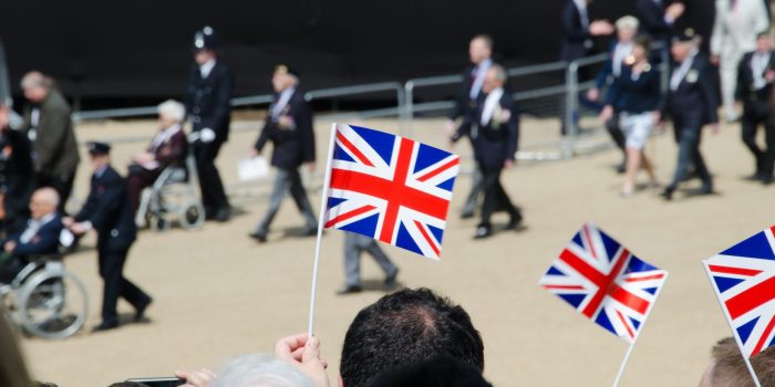 Crowds cheer on British army veterans as they walk through London.